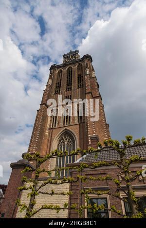Alta torre della chiesa tra le nuvole blu nella città di Dordrecht in Olanda. Foto Stock