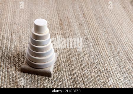 Piramide di legno su un tappeto di vimini, ombra da una palma. Spazio vuoto per il testo. Foto Stock