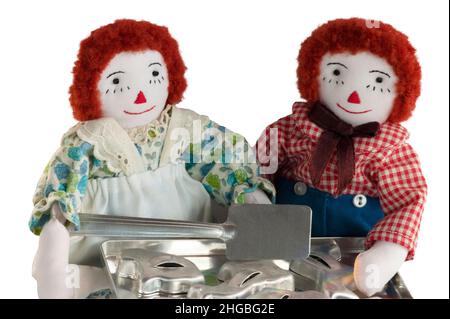 Bambole di stoffa di Andy Raggedy e Ann e Raggedy che cuocete biscotti con utensili, teglia e tagliatubi. Le bambole sono miniature fatte a mano. Foto Stock