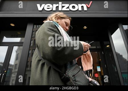 New York, Stati Uniti. 19th Jan 2022. Una donna tiene un telefono cellulare mentre cammina davanti ad un negozio al dettaglio Verizon a New York, NY, 19 gennaio 2022. Due operatori wireless, Verizon Communications Inc. E AT&T Inc., hanno accettato di non attivare circa 5G segnali vicino alle piste aeroportuali, oltre a preoccupazioni il segnale potrebbe interferire con le frequenze radio utilizzate per atterrare gli aerei e causare gravi interruzioni per i viaggi passeggeri.(Foto di Anthony Behar/Sipa USA) credito: Sipa USA/Alamy Live News Foto Stock