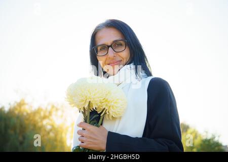 Profilo Vista laterale ritratto di attraente allegro sognante grigio-capelli media-età donna rilassante all'aperto durante la giornata di sole Foto Stock