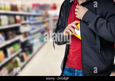 Taccheggio al dettaglio. Uomo rubare in Supermarket. Furto in negozio Foto Stock