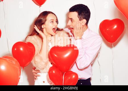 L'uomo con la sua bella ragazza innamorata ha scioccato . Giorno di San Valentino dell'amante. Coppia di San Valentino. Coppia sorpreso, molto felice, sconti, vendita, festa, sorridi, lau Foto Stock