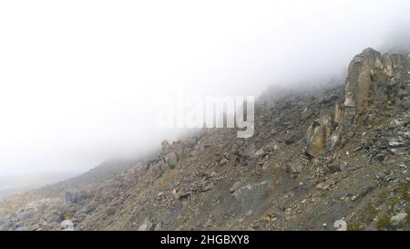 Montagne maestose in fitte nuvole. Paesaggio con belle rocce e nebbia drammatica, sfondo naturale. Foto Stock