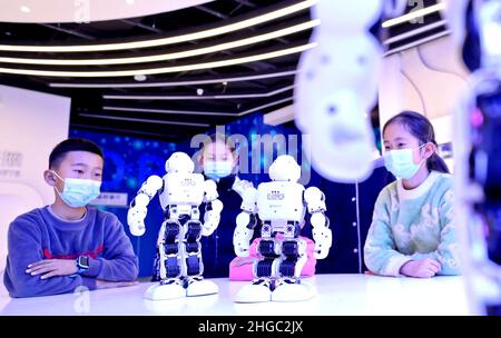 ZHANGYE, CINA - 19 GENNAIO 2022 - i bambini partecipano ad una performance di robot presso la zona di popolarizzazione della scienza e della tecnologia spaziale di Scien Foto Stock