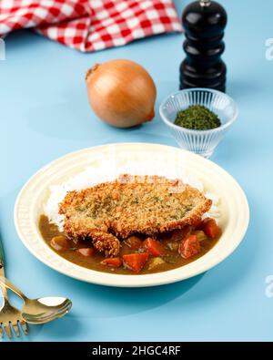 Riccio fritto di maiale con riso, cucina giapponese, su sfondo blu Foto Stock