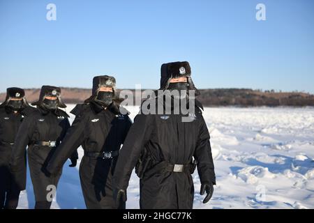 GRANDE KHINGAN, CINA - 20 GENNAIO 2022 - polizia di frontiera con il gelo di fronte che sfida le temperature di congelamento di meno 34 gradi Celsius pattuglia il confine dentro Foto Stock