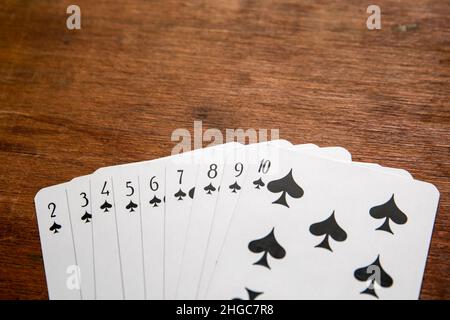 Carta da gioco su sfondo marrone di legno. Foto Stock