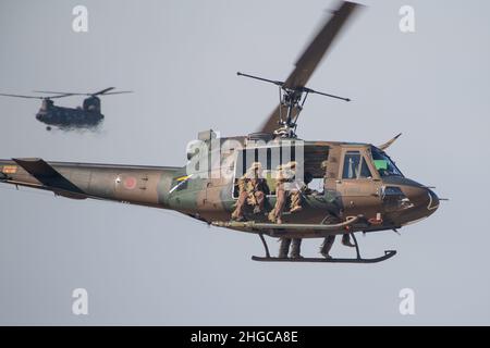 I soldati della forza di autodifesa del suolo giapponese della Brigata Airborne 1st, volano in una JGSDF UH-1 Iroquois sopra una zona di caduta paracadutista a Camp Narashino, Chiba, Giappone, durante il salto annuale di Capodanno il 13 gennaio 2022. I soldati JGSDF hanno condotto attacchi aerei per mostrare capacità di implementazione rapida a terra. (STATI UNITI Air Force foto di Senior Airman Brieana E. Bolfing) Foto Stock