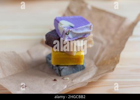 Sapone naturale fatto a mano. Pezzi di sapone multicolore fatti di materiali naturali sul tavolo Foto Stock