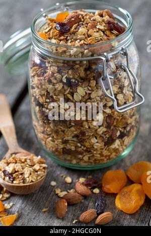 Granola nel vasetto di vetro sul tavolo di legno Foto Stock