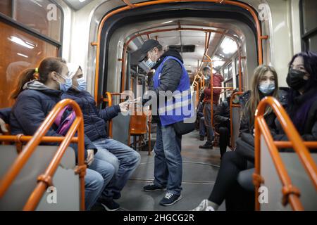 Bucarest, Romania - 19 gennaio 2022: L'uomo controlla i biglietti di trasporto all'interno di un vecchio tram a Bucarest. Foto Stock