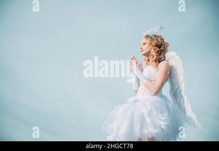 Cherubino. Giorno di San Valentino prega Cupido. Cielo. Felice ragazza angelo adolescente pregare. Biglietto d'auguri per le feste d'arte. Angelo ragazza con alone in abito angelo bianco. Carino Foto Stock