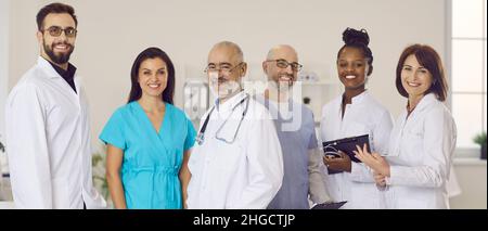 Personale felice e diversificato di clinica o ospedale in piedi insieme e sorridendo alla macchina fotografica Foto Stock