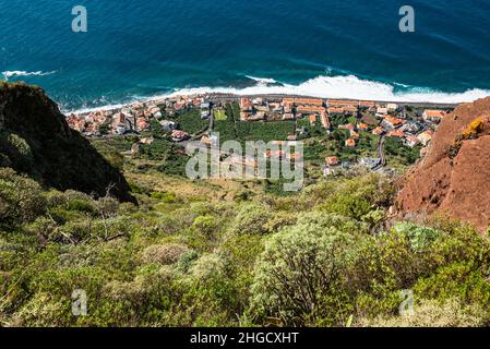 Vista elevata di Paul do Mar e la sua costa sull'Oceano Atlantico, presa dal sentiero escursionistico vicino al punto di vista “Miradouro da Raposeira”, Madeira Foto Stock