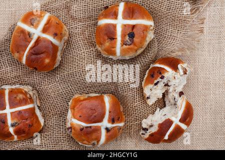 panini caldi a croce freschi e gustosi sulla superficie rustica Foto Stock