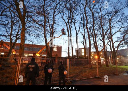 Amburgo, Germania. 20th Jan 2022. Gli agenti di polizia si trovano di fronte a un sito del Rindermarkthalle, dove gli alberi erano precedentemente occupati. Gli attivisti hanno protestato all'inizio del giovedì mattina contro la caduta di alberi a Neuer Pferdemarkt a St. Pauli. Tre persone erano salite negli alberi per impedire il lavoro di abbattimento, ha detto la polizia. Inoltre, molti altri attivisti si erano riuniti nel sito. Credit: Bodo Marks//dpa/Alamy Live News Foto Stock