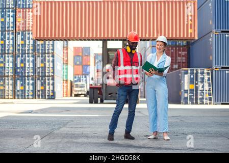 Donna d'affari e ingegnere parlare e controllare il carico contenitori scatola da carico nave da trasporto Cargo per l'esportazione di importazione. Spedizione in banchine. Foto Stock