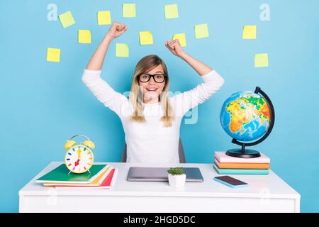 Ritratto di attraente intelligente intelligente brainy fortunata ragazza cheery facendo i compiti a casa gioendo isolato su sfondo di colore blu brillante Foto Stock