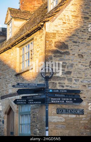 Cartello all'esterno di una casa all'angolo tra Witney Street e Guildenford all'alba in inverno. Burford, Cotswolds, Oxfordshire, Inghilterra Foto Stock