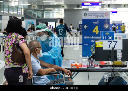 Bangkok, Thailandia - 25 gennaio 2022 : medico asiatico che dà vaccini antivirali covid colpo di richiamo al paziente uomo anziano indossando maschera protettiva. Foto Stock