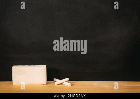 Scacchiera scolastica, scacchiera vuota nera, pezzo di gesso bianco e spugna sulla soglia del telaio in legno, spazio copia Foto Stock