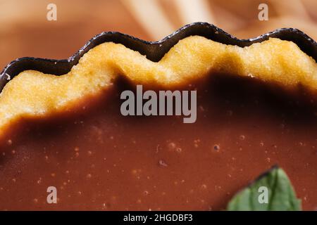 Crostate di cioccolato su sfondo grigio, decorate con foglie di menta e arancio secco Foto Stock