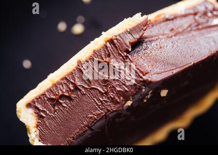 Crostate di cioccolato su sfondo grigio, decorate con foglie di menta e arancio secco Foto Stock