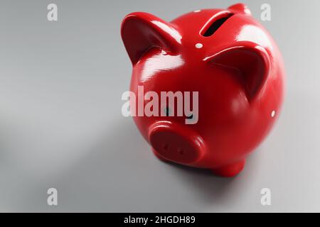 Contenitore piggybank rosso brillante sulla superficie grigia, cosa vuota per mettere soldi Foto Stock