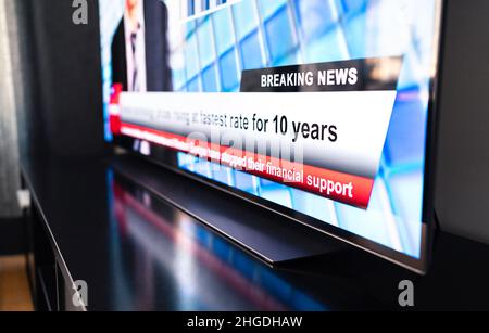 Ultime notizie in tv. Titolo newscast dal vivo. Televisore sul tavolo, schermo in primo piano. Trasmissione giornaliera dello spettacolo mattutino. Disinformazione, propaganda. Foto Stock