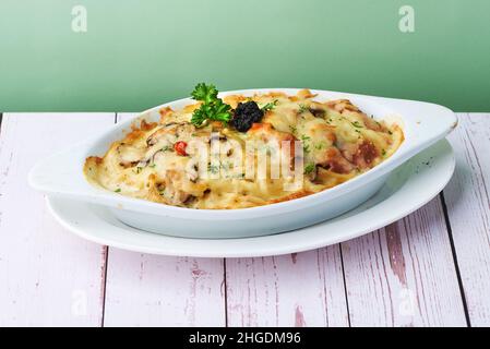 Crema di tartufo di pasta al forno con formaggio, olive, pasta, pollo e verdure gratinate in piatto da forno Foto Stock