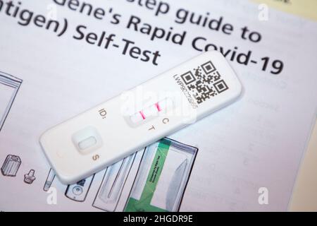 Test di flusso laterale / LFT / LFD / Lateral flow device kit che ha dimostrato positivo (mostrando due linee rosse) per il coronavirus del virus COVID 19 durante il test casa antigene, a Londra. REGNO UNITO. Il test di flusso cinese (condotto da Orient gene in Cina) ha rilevato virus nel campione di tampone nasale prelevato dal naso. (128) Foto Stock