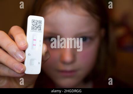Undici anni / 11 anni anno 7 studente / bambino / bambino / ragazza che tiene il suo test di flusso laterale / LFT / LFD / Lateral flow device kit dopo aver provato positivo (mostrando due linee rosse) per il coronavirus virus COVID 19 durante il test Antigen home, a Londra. REGNO UNITO. Il test di flusso cinese (condotto da Orient gene in Cina) ha rilevato virus nel campione di tampone nasale prelevato dal naso. (128) Foto Stock
