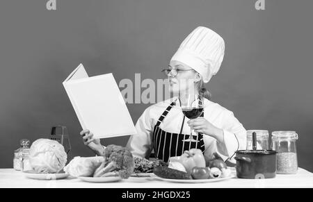 fai pratica di più. chef professionista che legge la ricetta per cucinare. cuoco femminile che prepara il piatto. cuoci in cucina. Apri il ricettario per una cucina sana Foto Stock