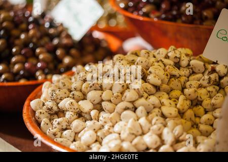 Ciotole di spicchi d'aglio marinati e olive in vendita sul mercato francese Foto Stock