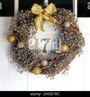 Tradizionale corona di natale appeso alla porta di fronte del 19th secolo cottage - Berkshire, Inghilterra, Regno Unito Foto Stock
