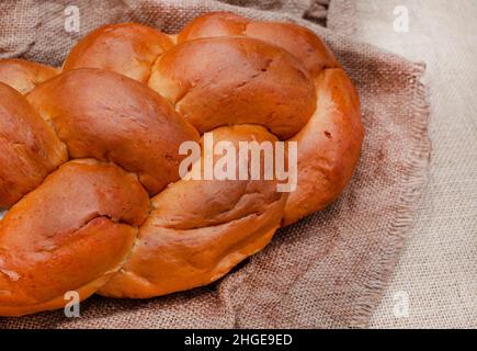 Challah o pane intrecciato su superficie rustica Foto Stock