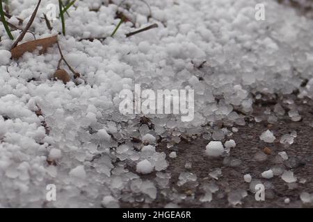 Amburgo, Germania. 20th Jan 2022. I grani di neve giacciono sulla strada. Nel pomeriggio, nevicate pesanti e docce di slittino caddero sopra la zona della città di Amburgo. Il Servizio meteorologico tedesco avvertì di raffiche di forza 7 (circa 55 km/h) nell'entroterra di Amburgo e Schleswig-Holstein, e raffiche di forza 8 dal nord-ovest vicino alle docce. Credit: Jonas Walzberg/dpa/Alamy Live News Foto Stock