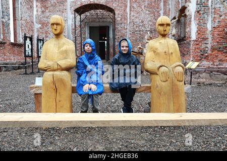 Due bambini seduti sul banco della Chiesa luterana, Karelia, Lahdenpohja Foto Stock