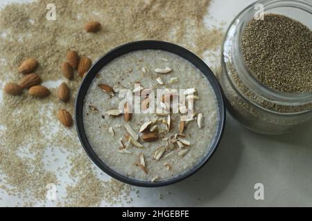 Porridge di miglio di Barnyard. Un porridge facile e sano per la colazione con miglio da cortile, latte e mandorle. Girato su sfondo bianco con il barnyard mi Foto Stock