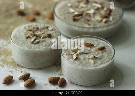 Porridge di miglio di Barnyard. Un porridge facile e sano per la colazione con miglio da cortile, latte e mandorle. Girato su sfondo bianco con il barnyard mi Foto Stock