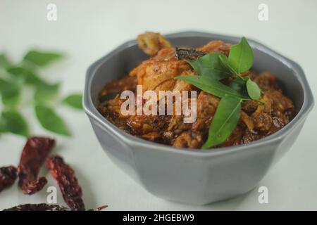 Sugo di pollo. Sugo di pollo semi-secco preparato in stile Kerala con cipolle, pomodori e spezie. Scatto su sfondo bianco Foto Stock