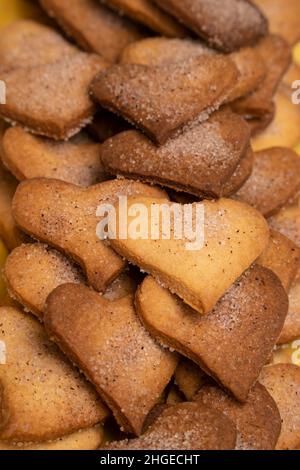 Biscotti semplici fatti in casa a forma di cuore, decorati con zucchero e cannella. Foto Stock