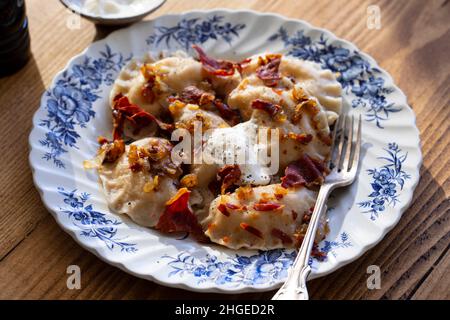 Gnocchi tradizionali, pierogi, con cipolla fritta e pancetta Foto Stock