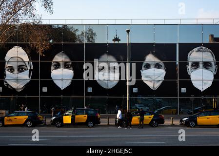 Spagna. 19th Jan 2022. Un grande cartellone raffigurante i volti che indossano una maschera contro covid19 è visto all'esterno di un centro di vaccinazione nella Fira di Barcellona, in Spagna, il 19 gennaio 2021. (Foto di Davide Bonaldo/Sipa USA) Credit: Sipa USA/Alamy Live News Foto Stock