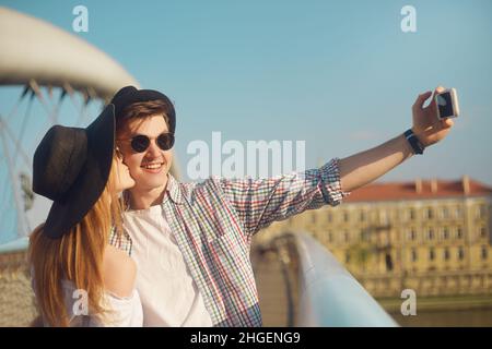 Coppia sorriso sul ponte. Turista divertirsi sulla vacanza avventura di viaggio sumer. I turisti felici scattano foto di se stessi sullo smartphone. Weeknd in Euro Foto Stock