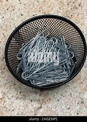 Vista dall'alto del contenitore in filo nero di graffette in carta a nastro. Foto di alta qualità Foto Stock