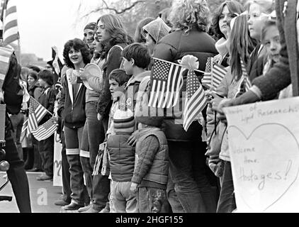 I residenti aspettano lungo Pennsylvania Avenue per dare il benvenuto a casa ai 52 ostaggi americani durante una sfilata di ritorno a casa 27 gennaio 1981 a Washington, DC. Gli ostaggi sono stati tenuti prigionieri per 444 giorni dai radicali iraniani presso l'ex Ambasciata degli Stati Uniti a Teheran. Foto Stock