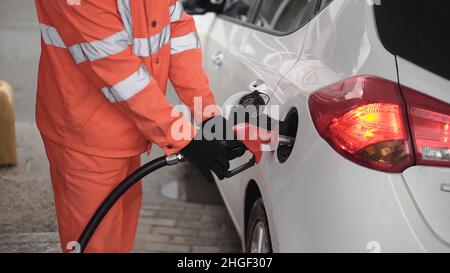 Addetto alla stazione di servizio rifornimento auto presso la stazione di servizio. Clip. L'operatore del gas maschile riempie la vettura. Foto Stock