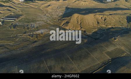 Vista panoramica aerea del campo verde, alte montagne vicino al laghetto su mare blu e cielo nuvoloso sfondo. Bellissimo paesaggio con alto verde hi Foto Stock